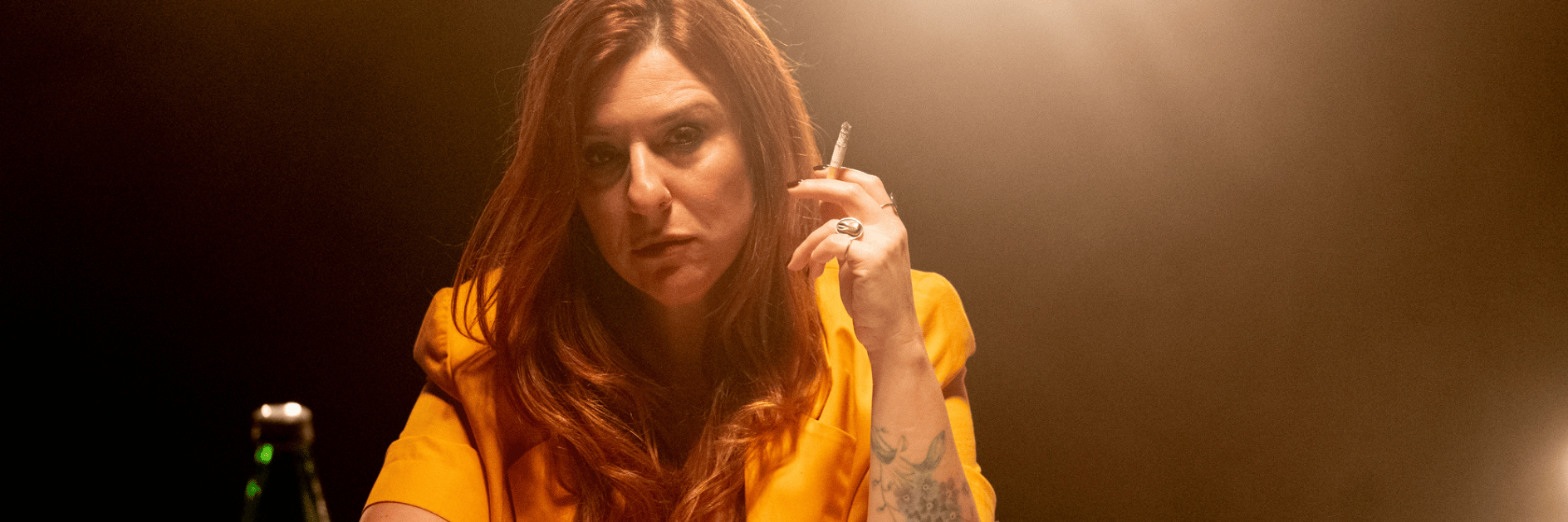 Foto di una donna seduta a un tavolo che fuma una sigaretta